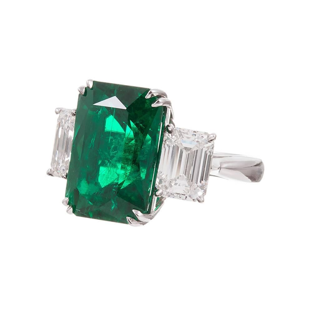 An incredible handmade ring, rendered in platinum specifically for these three special gemstones. The center emerald weighs an impressive 10.28 carats and is accompanied by an AGL gemlab certificate. The emerald cut diamonds weigh 3.42 carats