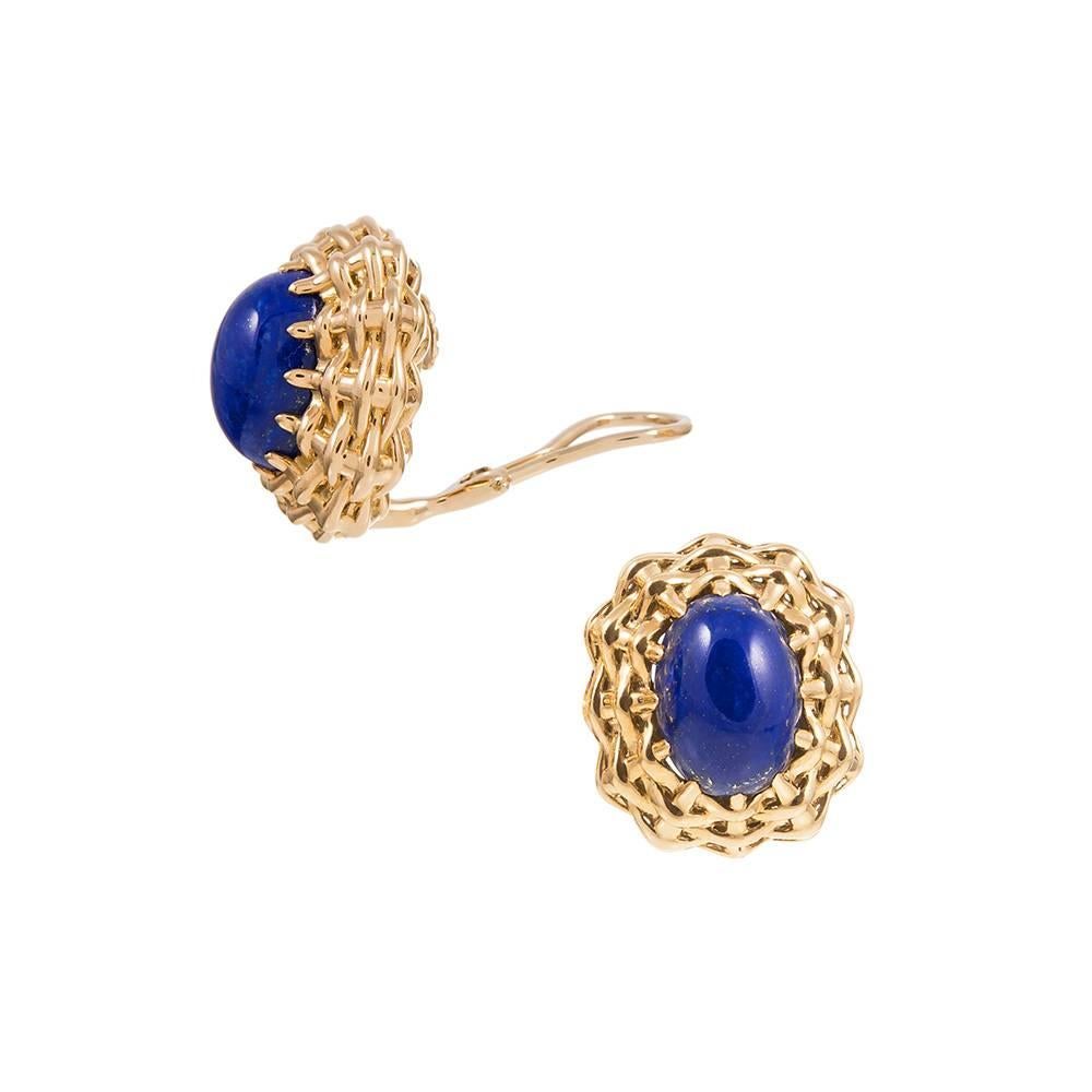 A striking lapis lazuli cabochon sits stop a woven nest of 18 karat yellow gold, part of the “Lightship” collection, compliments of American jewelry icon Seaman Schepps. Currently clips, a post can be added on request for those with pierced ears.