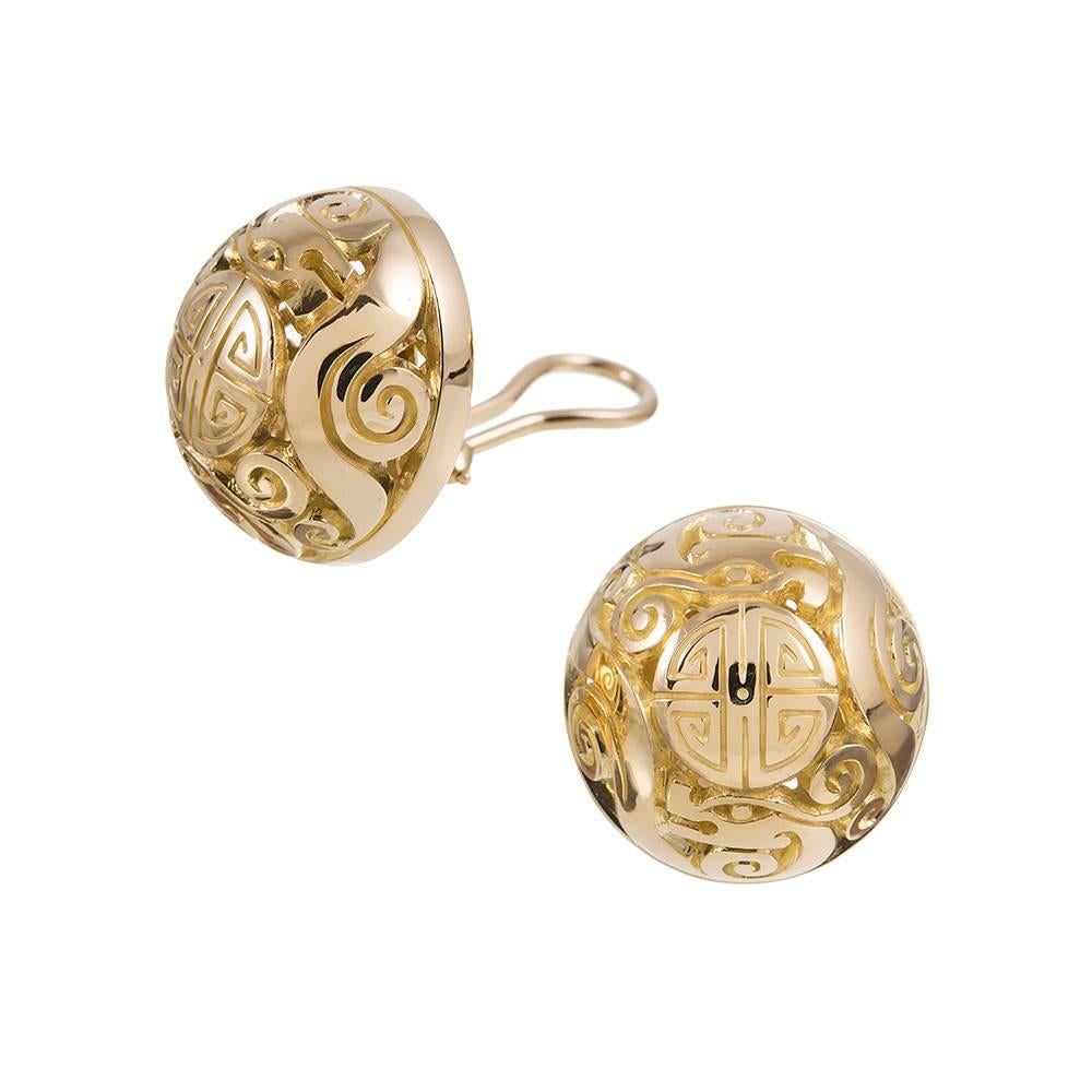 Carved gold button earrings measuring 3/4 of an inch in diameter, part of the “Canton” collection, compliments of iconic American jeweler Seaman Schepps. Mounted in 18 karat yellow gold. Currently clips, a post can be added on request for those with