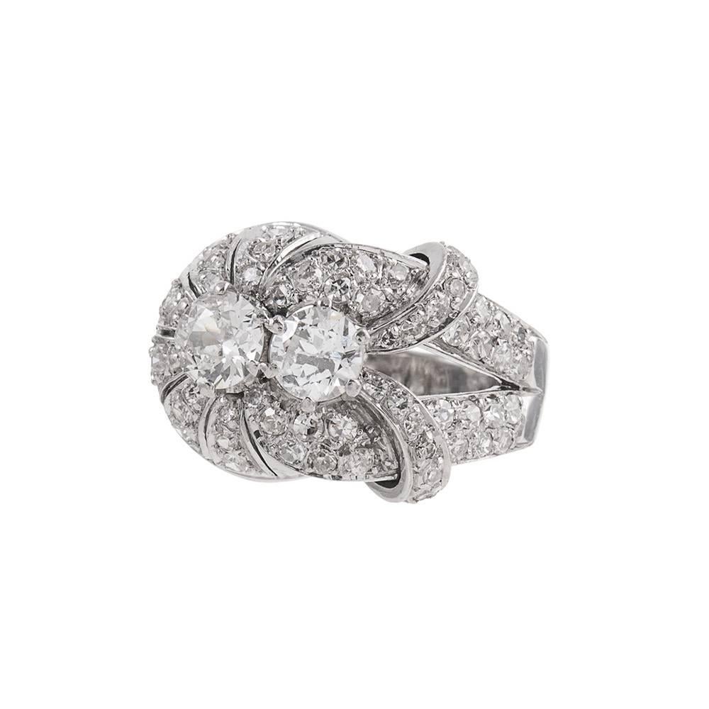 A charming vintage creation from the late retro period and likely crested in the late 1940s or early 1950s. Rendered in platinum and set in the center with two major diamonds that weigh 1.15 carats in total, the asymmetrical design is further