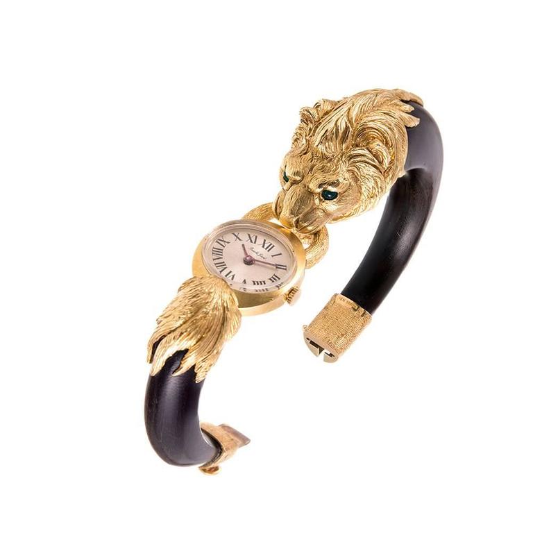 The piece bears French hallmarks and appears to be from the Gay Freres collection, although it is not signed. The lion’s head is artfully carved with beautiful detail and his eyes set with cabochon emeralds. The center is a manual wind watch signed