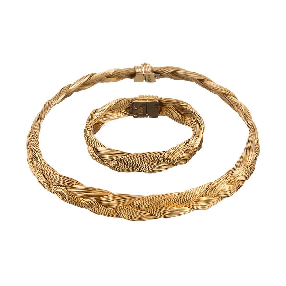 A feminine, substantial, wearable and incredibly chic necklace and bracelet suite, designed as clusters of golden strands fashioned into a single braid. The absence of gemstones allows this suite to be a subtle addition to informal attire, yet it