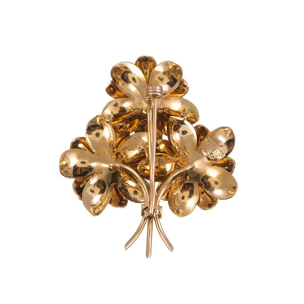 A sweet creation, compliments of Tiffany & Co. Approximately .50 carats of rubies form the centers of the flowers in this charming golden bouquet. 18k yellow gold. This piece measures 1.6 by 1.6 inches. 