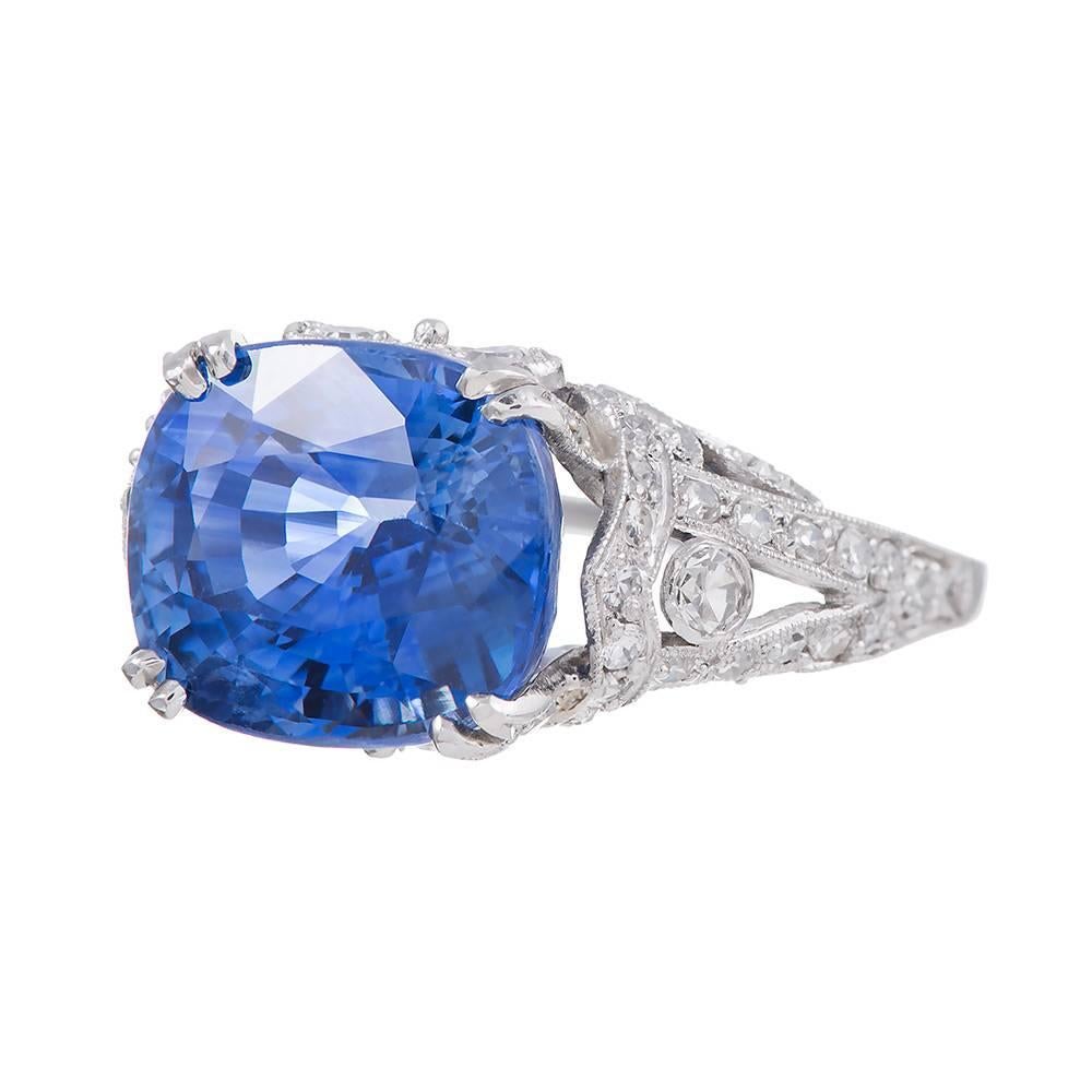An ultra-feminine creation, rendered in platinum, the mounting set in the center with an oval brilliant cornflower blue sapphire that weighs 9.03 carats. The stone exhibits truly stunning color. It is decorated with 1.05 carats of white diamonds,