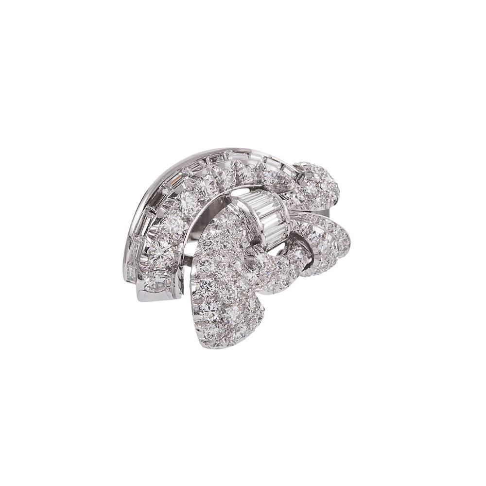 An amusing design, created with great artistic inspiration and flair. Round and baguette diamonds are assembled in an asymmetrical pattern abstractly resembling a bow. The platinum ring is set with approximately 3.00 carats of white diamonds. Hand
