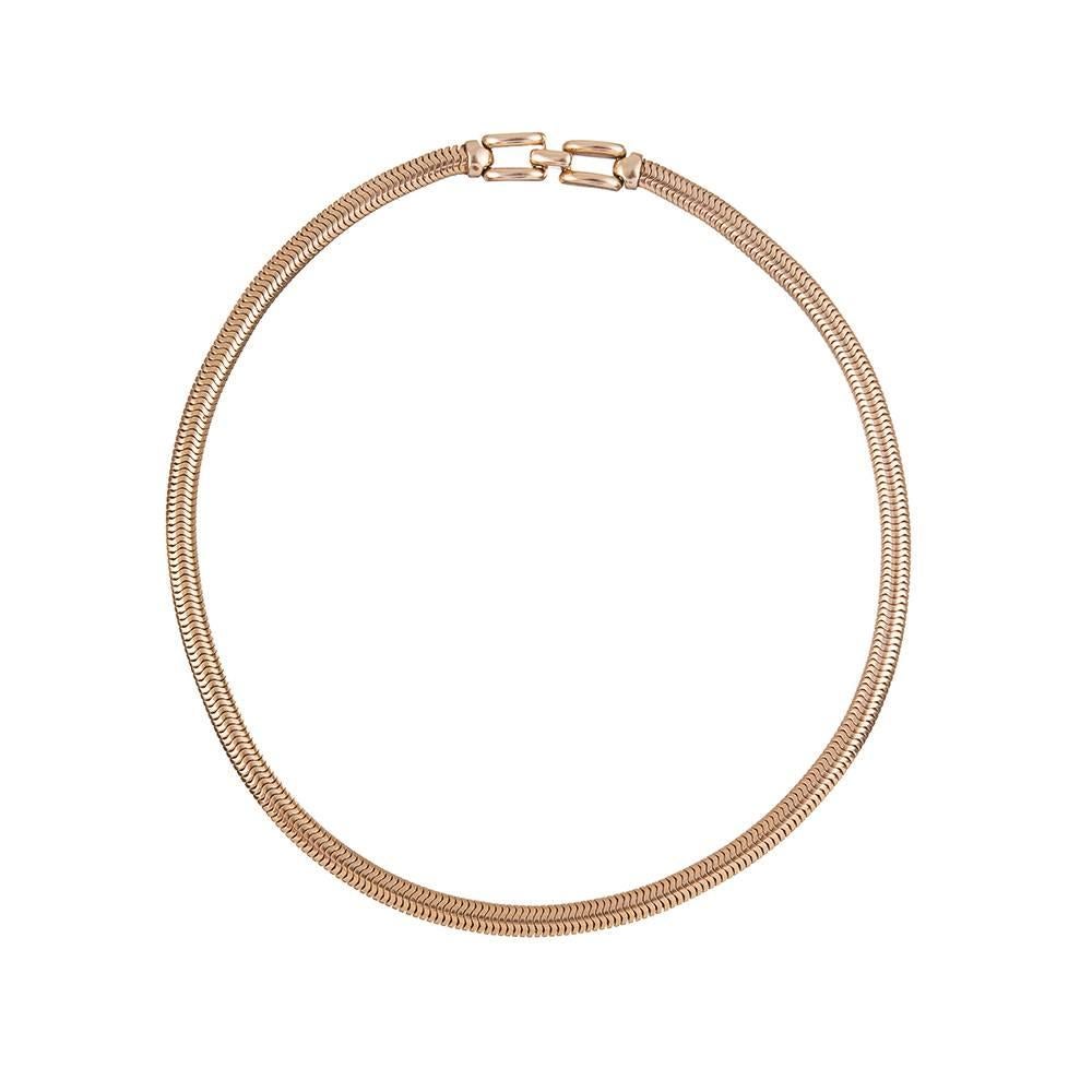 A classic design, compliments of style icon Tiffany & Co. Unencumbered by gemstones or other embellishments, the 14k yellow gold snake chain collar measures 16 inches long and is finished with a stylized clasp. Signed and hallmarked.