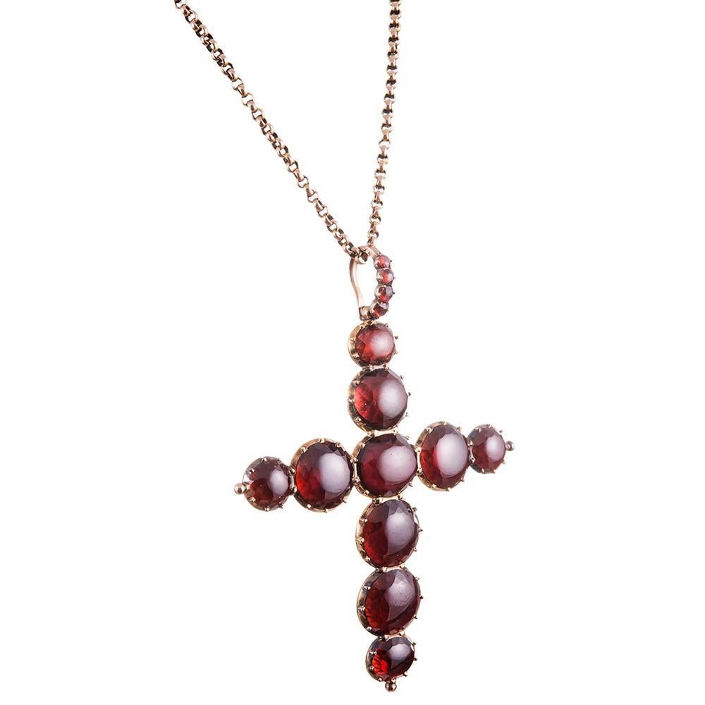 Large garnets, with domed cabochon tops and subtly faceted girdles are assembled in the shape of a cross and capped on the back in 9 carat rose gold. This impressive mid-Victorian treasure measures 3.25 by 2.5 inches including the gemstone set bale