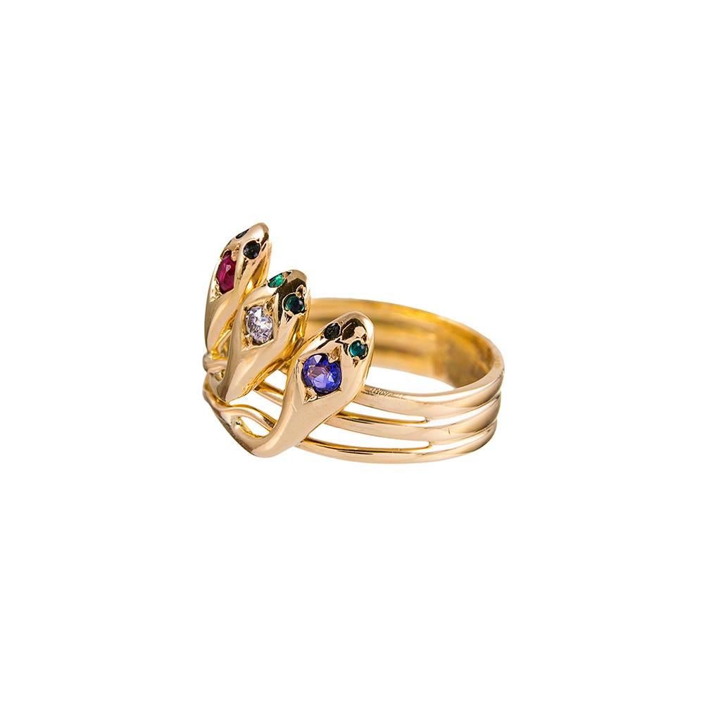 Made of 14k yellow gold and decorated with three snakes, their heads and eyes set with gemstones. A solitary diamond, ruby and sapphire offer a hint of Americana, while emeralds sparkle in their eyes. Size 7.25 can be resized on request.