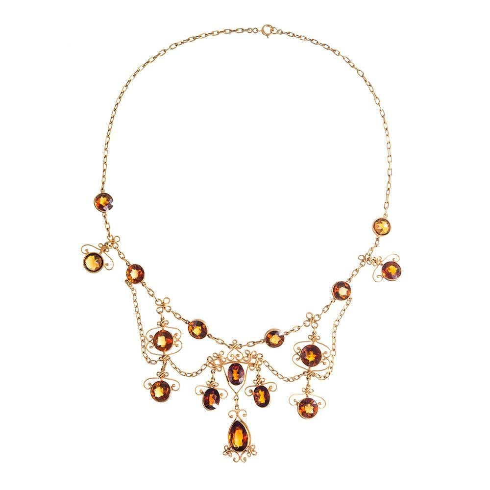 14k yellow gold classic festoon style necklace decorated with scrolling golden wirework and numerous faceted citrines. This “layered” design drapes beautifully about the neck and looks beautiful with skin or fabric peeking through the scrolling open