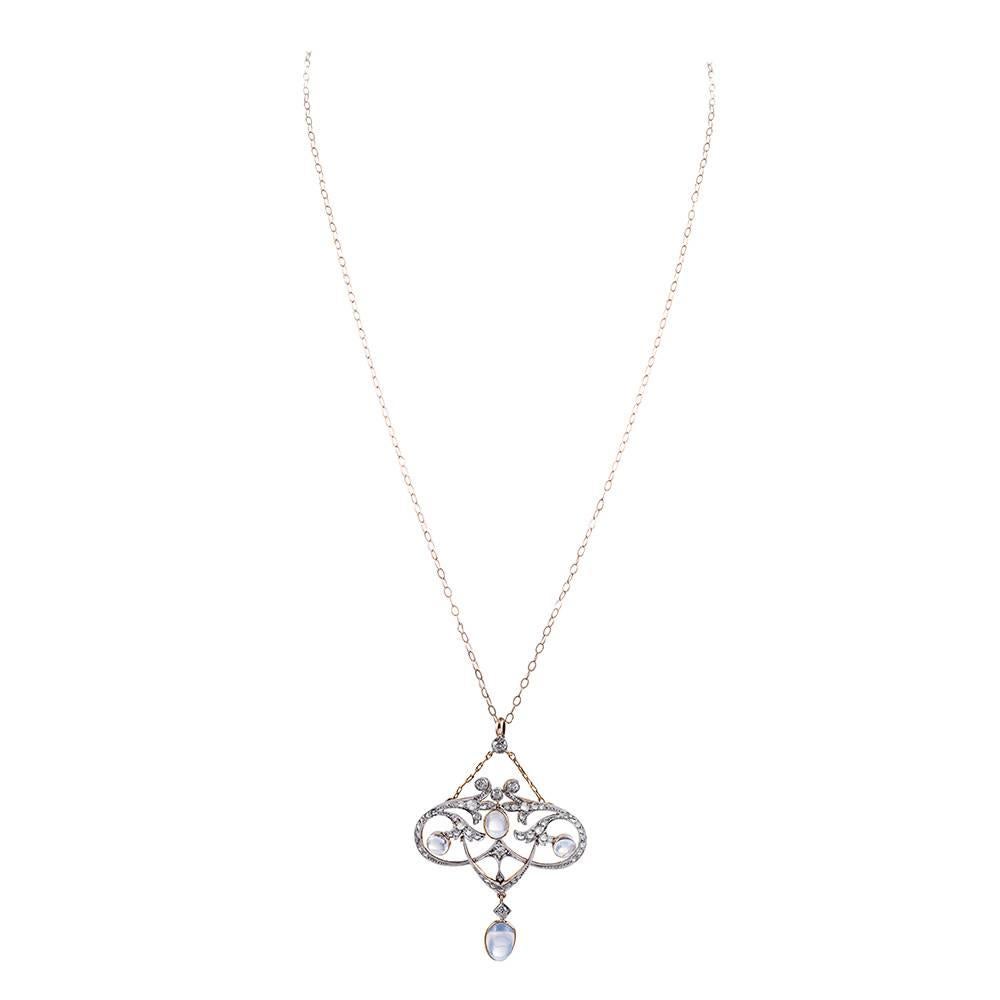 Made of platinum and 18k yellow gold, this ultra-feminine Edwardian creation is decorated with cabochon blue flash moonstones and rose cut diamonds, circa .25 carats in total. The sweeping strokes are fluid and organic. 2.5 by 1.75 inches and
