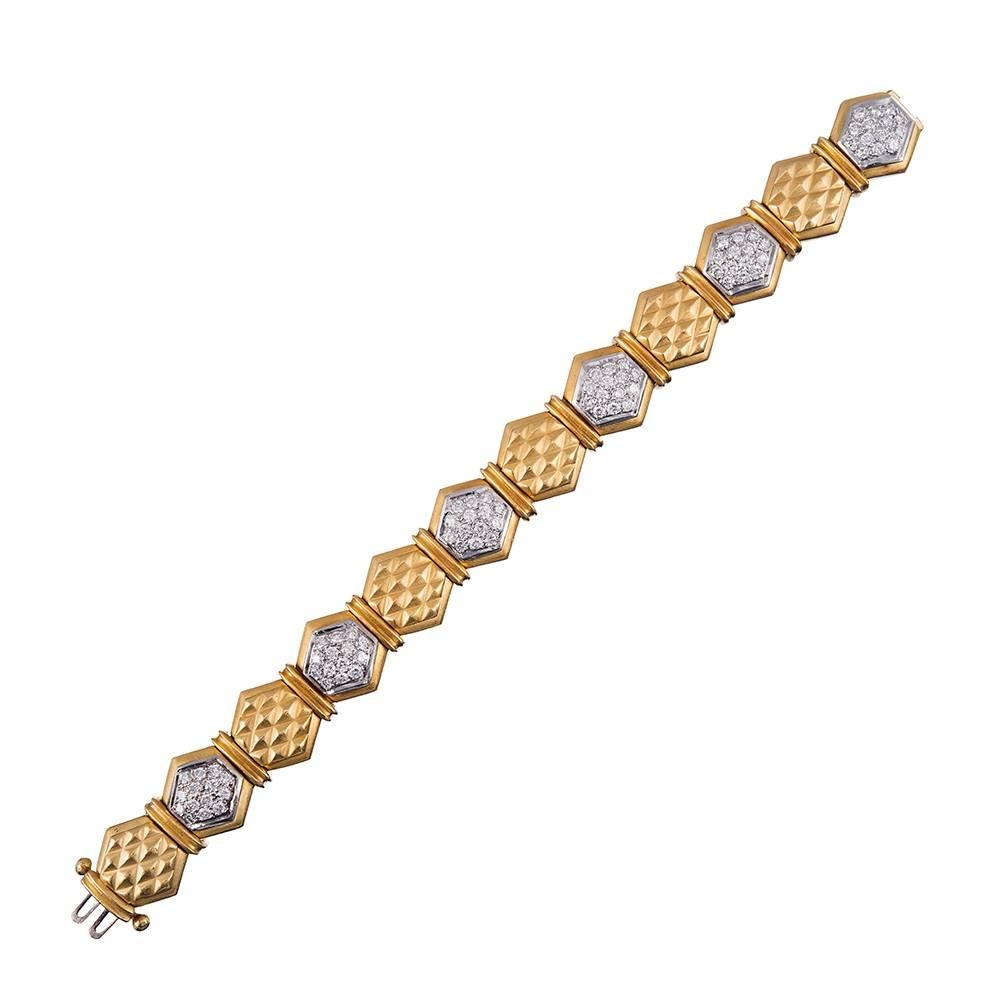 Brushed links of 18k yellow gold textured with a three-dimensional honeycomb pattern alternate with diamond-studded octagons and are separated by double bridges of gold. This bracelet has distinct late 20th century character and is bold enough to