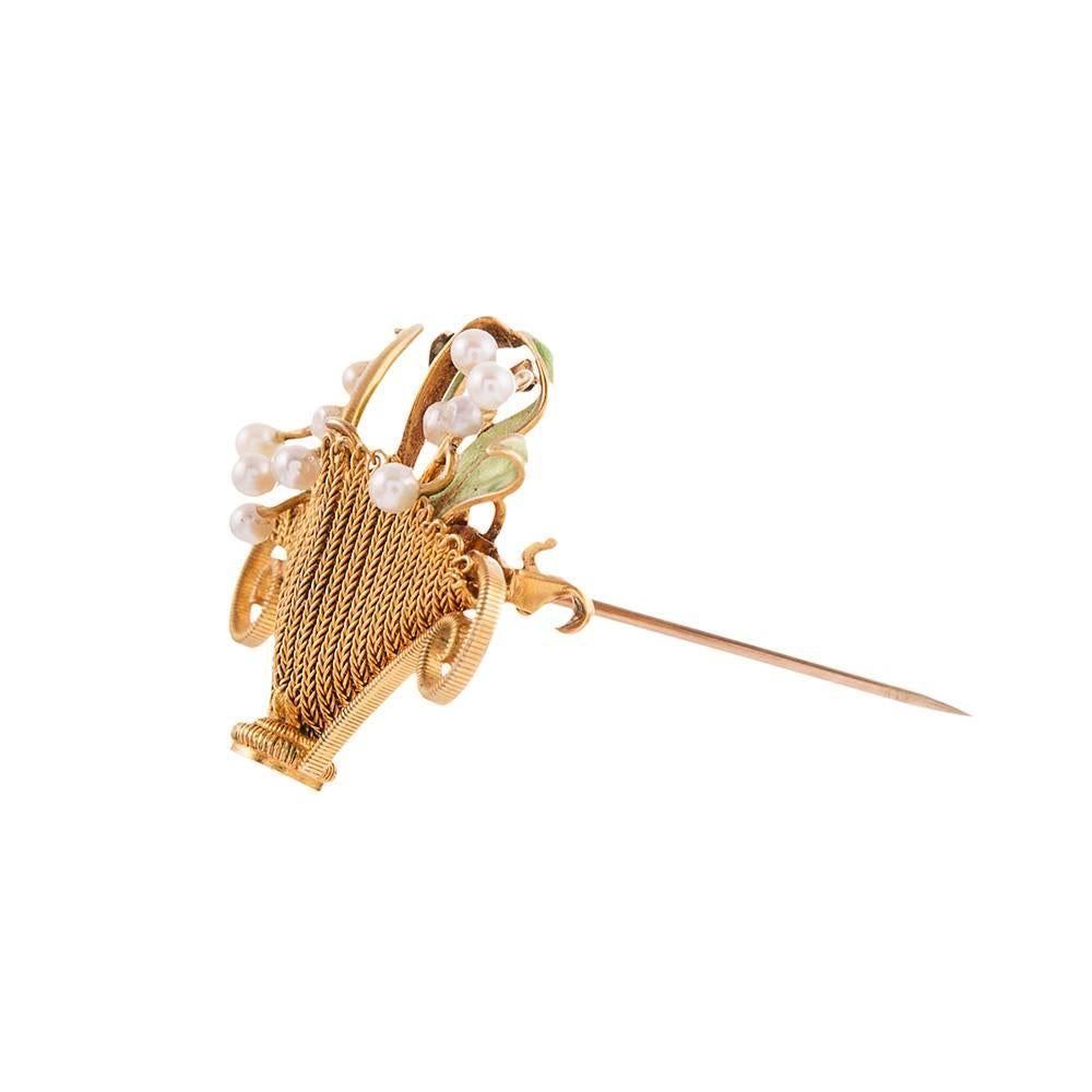 14k yellow gold basket pin, decorated with green enamel and pearls, creating the form of a flower basket with blooms erupting form the top. Note the subtle color hues of the green enamel and the incredible woven texture of the gold. Art Nouveau