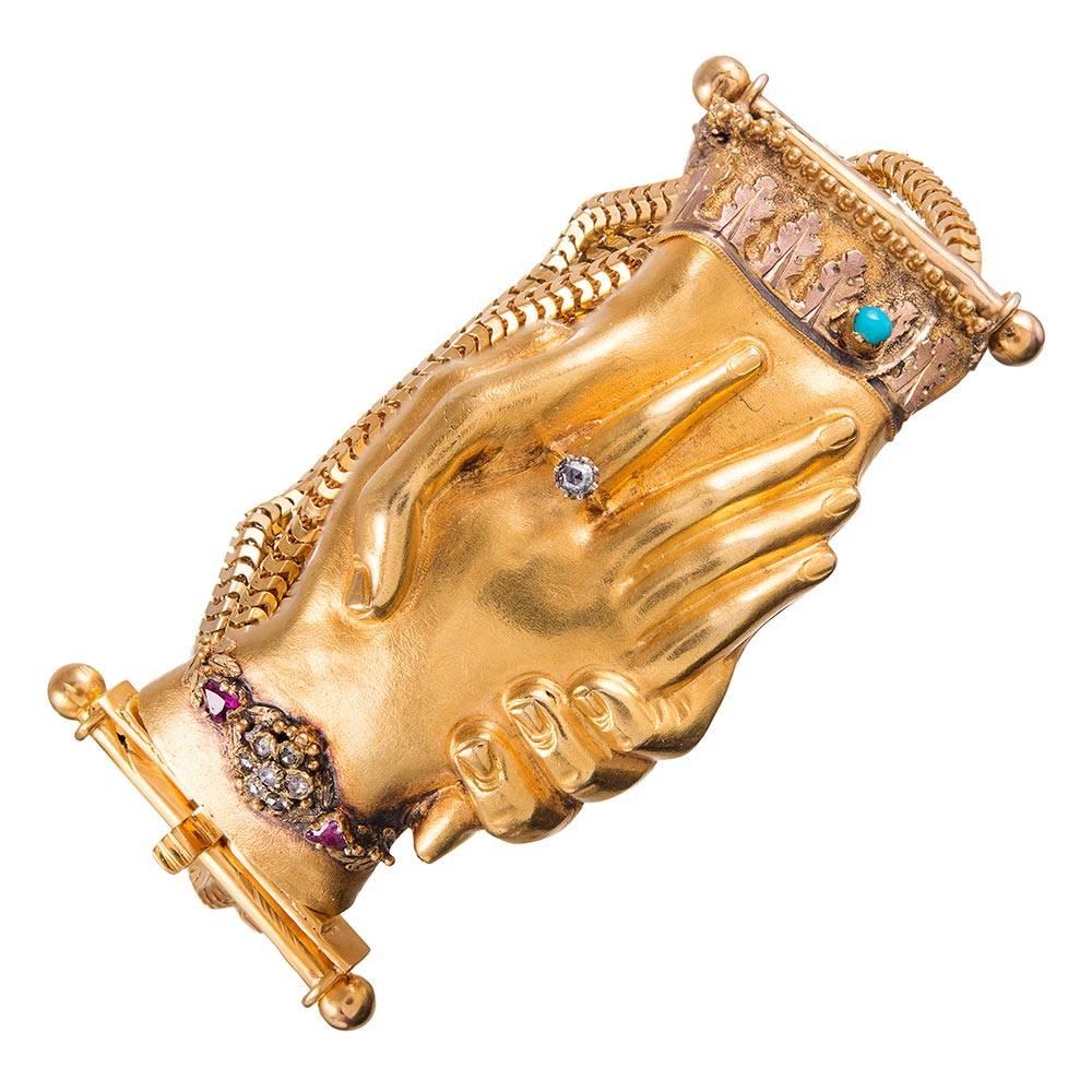 An exceptional and unique Victorian creation with marvelous detail and whimsical character, the bracelet is rendered in 14k yellow gold and measures just over an inch wide & 7 inches long. Beautifully detailed hands hold each other and are