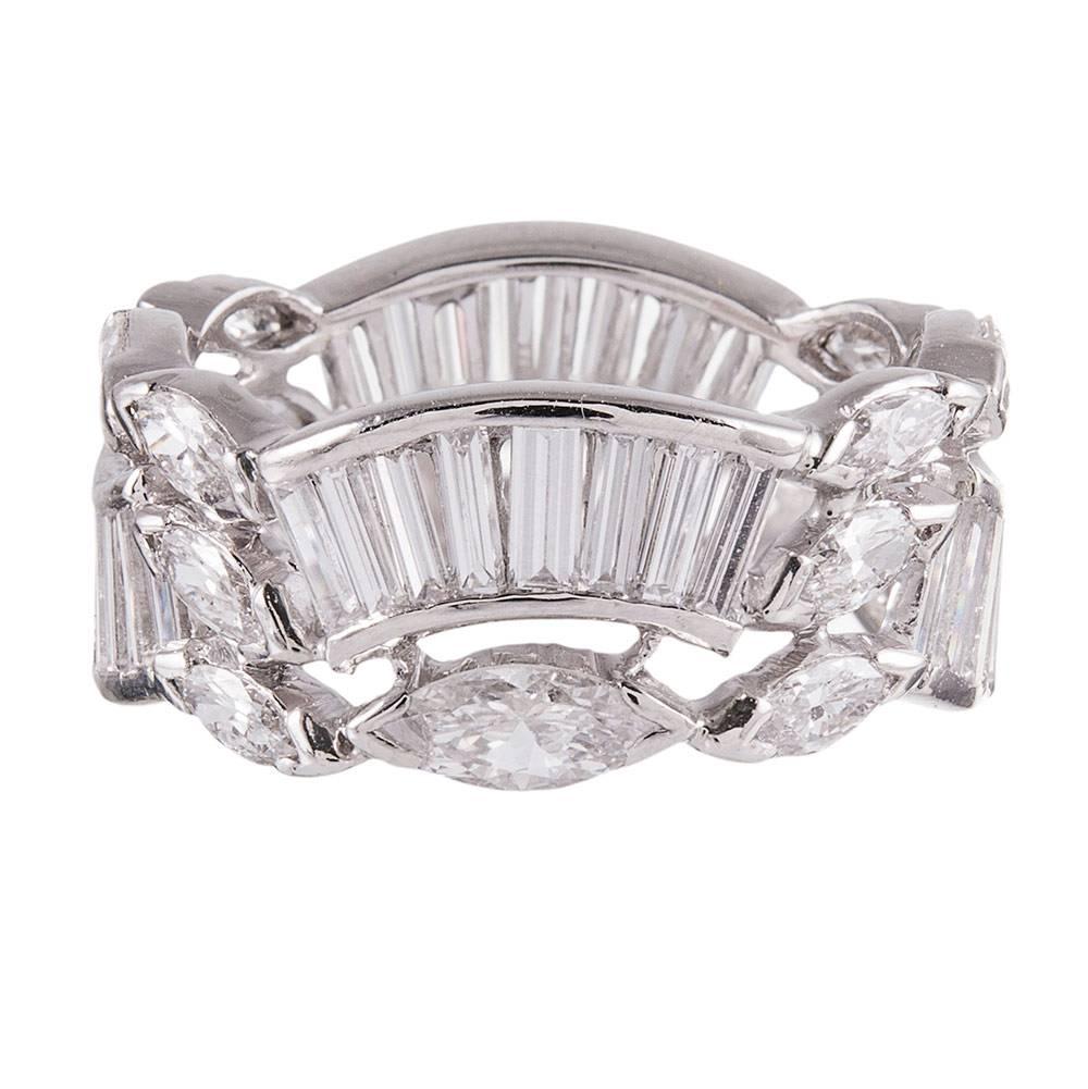 A platinum eternity band with an unusual and distinctive design compromised of a scalloped pattern of baguette- and marquis cut white diamonds. The stones weigh 3.10 carats combined. Size 5.75 can be resized on request.