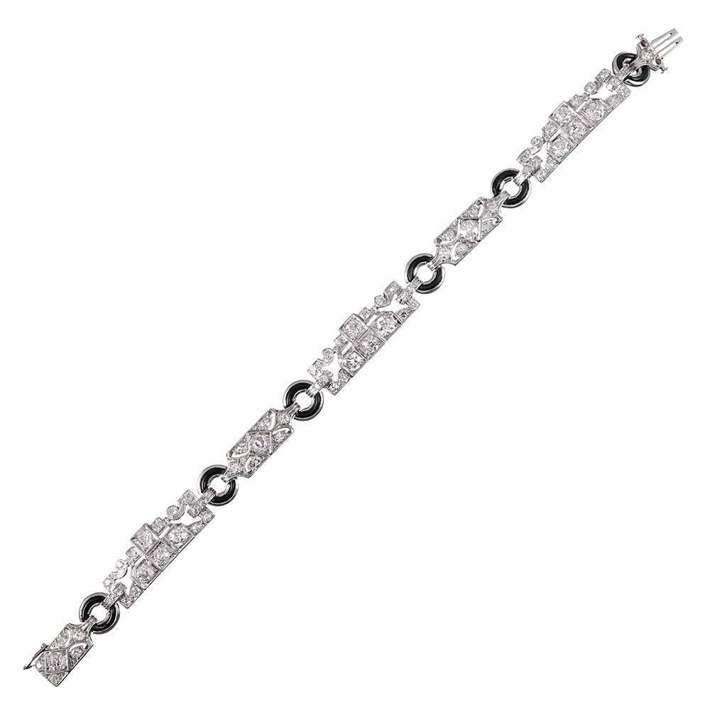 Combining classic art deco glamour with uniquely-styled rectangular links with asymmetrical edges, the bracelet is decorated with 5.00 carats of old European brilliant white diamonds, the alternating sections connected by circular onyx bridges. 7.25