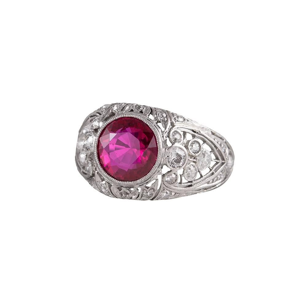 A gorgeous filigree and diamond setting for an equally beautiful center gemstone. This ruby exhibits absolutely stunning intense red color that will delight the enthusiast of art deco treasures. The round ruby weighs 2.02 carats and is complimented