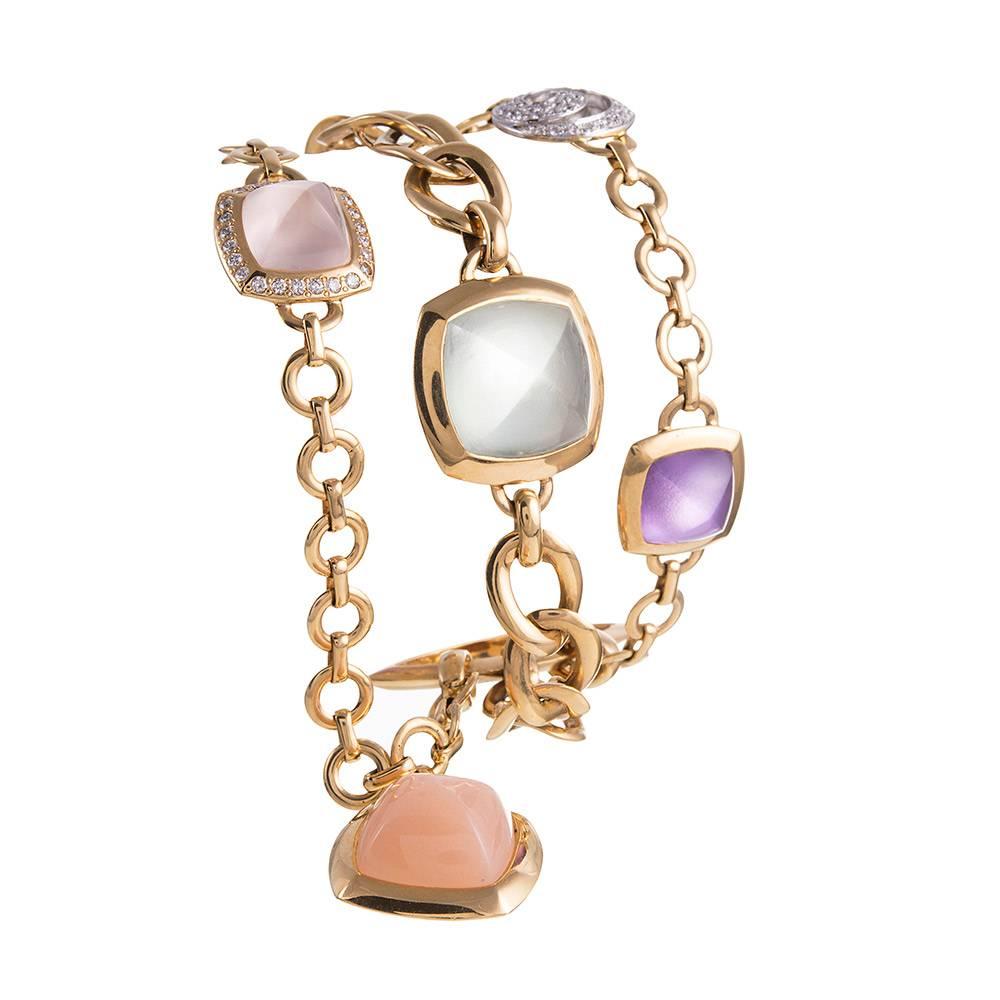 18 karat yellow gold bracelet, a modern evolution of a charm bracelet, designed as three rows of assorted chain links set with various sugarloaf gemstones and accented with well-placed brilliant white diamonds. The gemstones weigh 44 carats in total