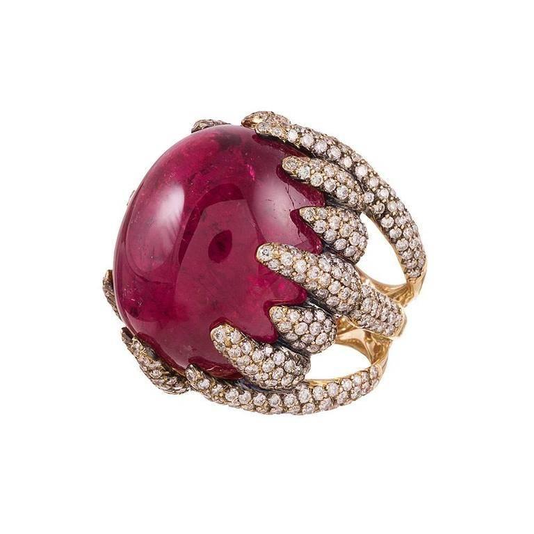An enormously delicious cabochon of pink tourmaline sits suspended in a frame of 18 karat yellow gold with diamonds flames licking at its sides. The tourmaline weighs an impressive 95 carats, while approximately 4.00 carats of diamonds grading as