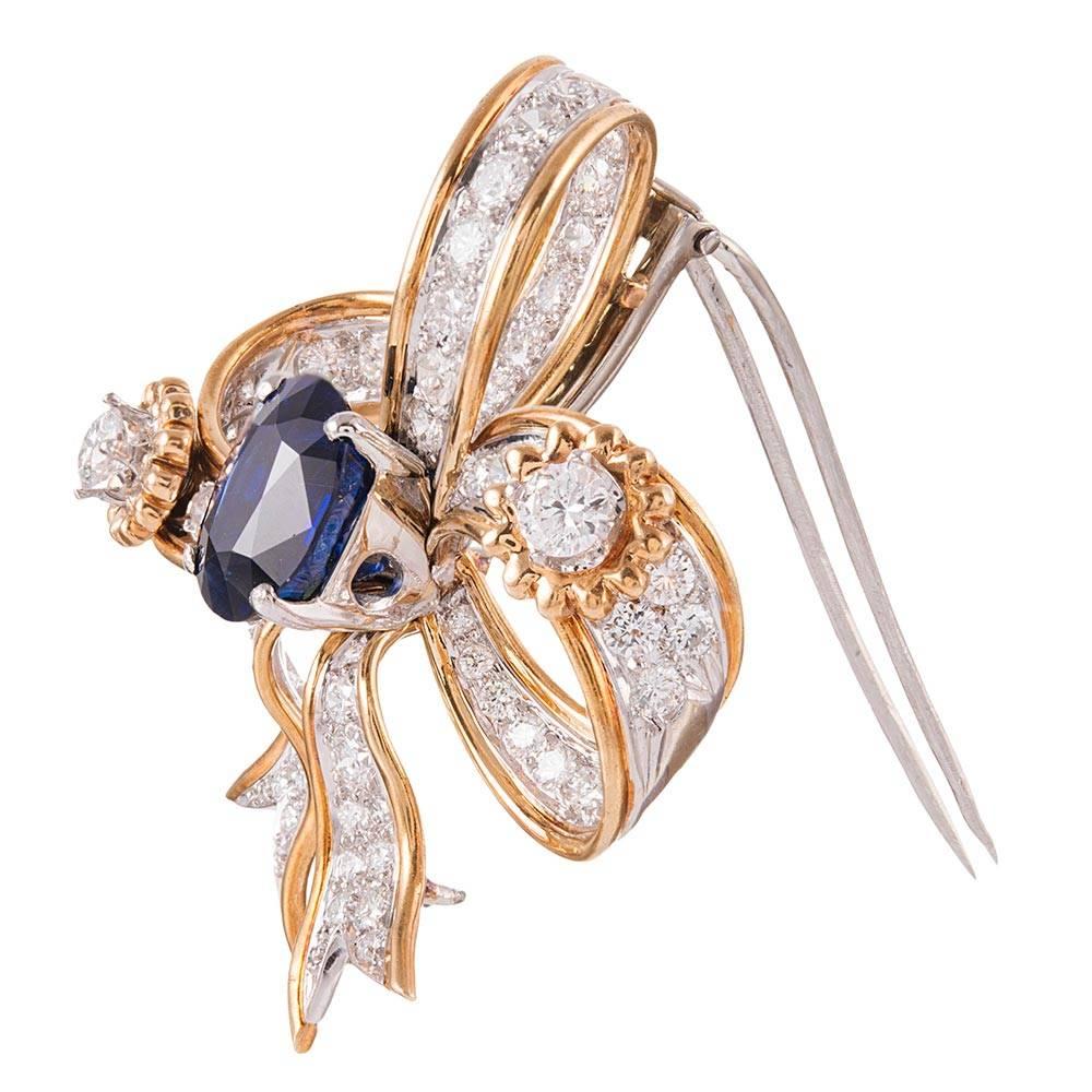 Charming and sweet, with just enough substance to catch your eye, this glistening bit of finery will carry you from day to evening attire with ease. 1.5 by 1.25 inches in diameter and set with a 3.24 carat oval faceted sapphire, then decorated with