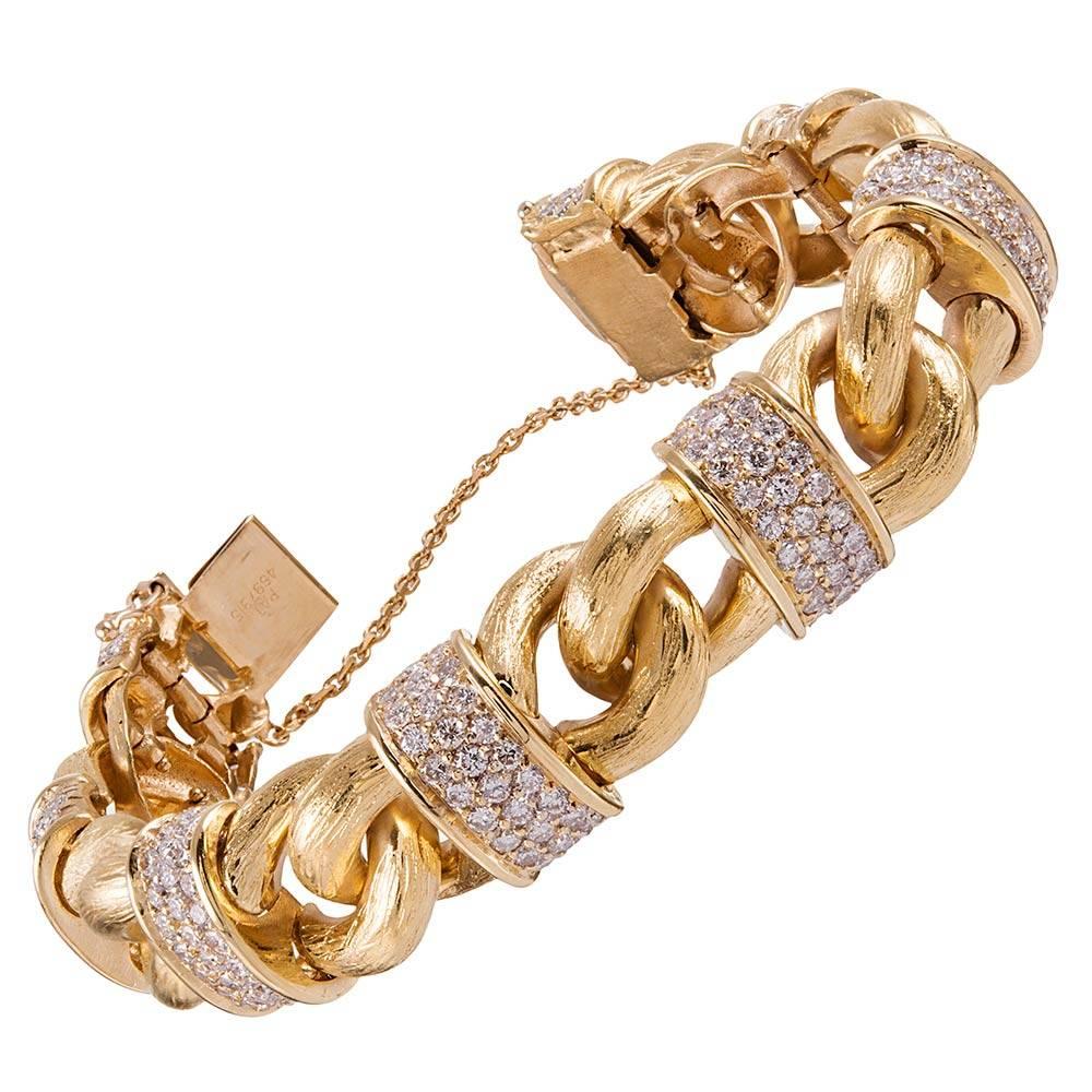 Classic sections of golden chain link are married by diamond-set bridges, creating a bow-like design that repeats throughout the bracelet. 7.50 carats of brilliant round white diamonds adorn your wrist. 7 inches long and finished with a safety chain