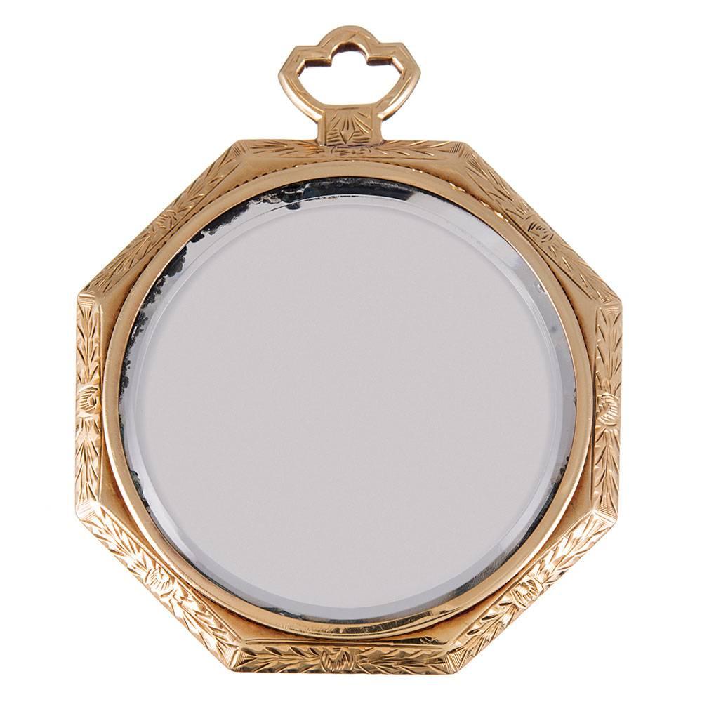 A charming accessory for the vintage enthusiast, this 18k yellow gold makeup mirror was made in the 1930s and is simply oozing art deco character. A hand-engraved golden frame of both yellow and rose gold is finished on one side by a round mirror