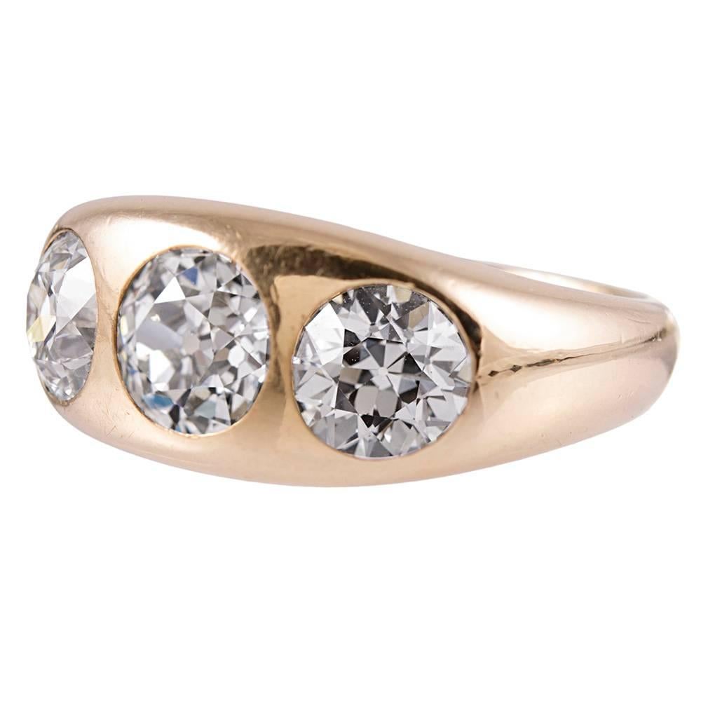 A substantial three stone ring for the vintage enthusiast, created in a size suitable for a lady or a gentleman. Made of 18k yellow gold, the gypsy style ring is set in the center with a 1.35 carat old European cut diamond, which is flanked on each