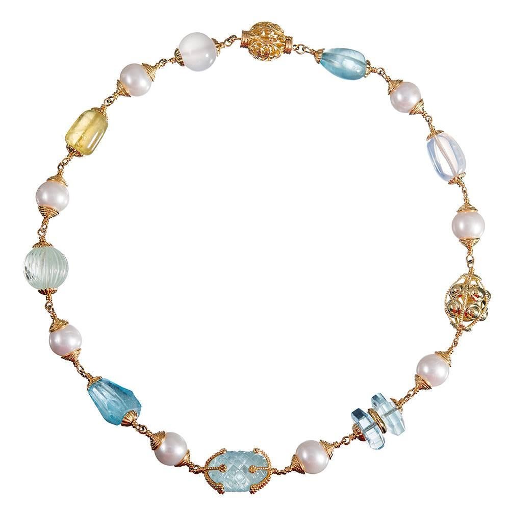 A 18 inch long and visually symbiotic collection of gemstones and pearls, compliments of American jewelry icon Seaman Schepps. The arrangement consists of blue topaz, aquamarine, green beryl, moonstone & pearls capped by golden findings and