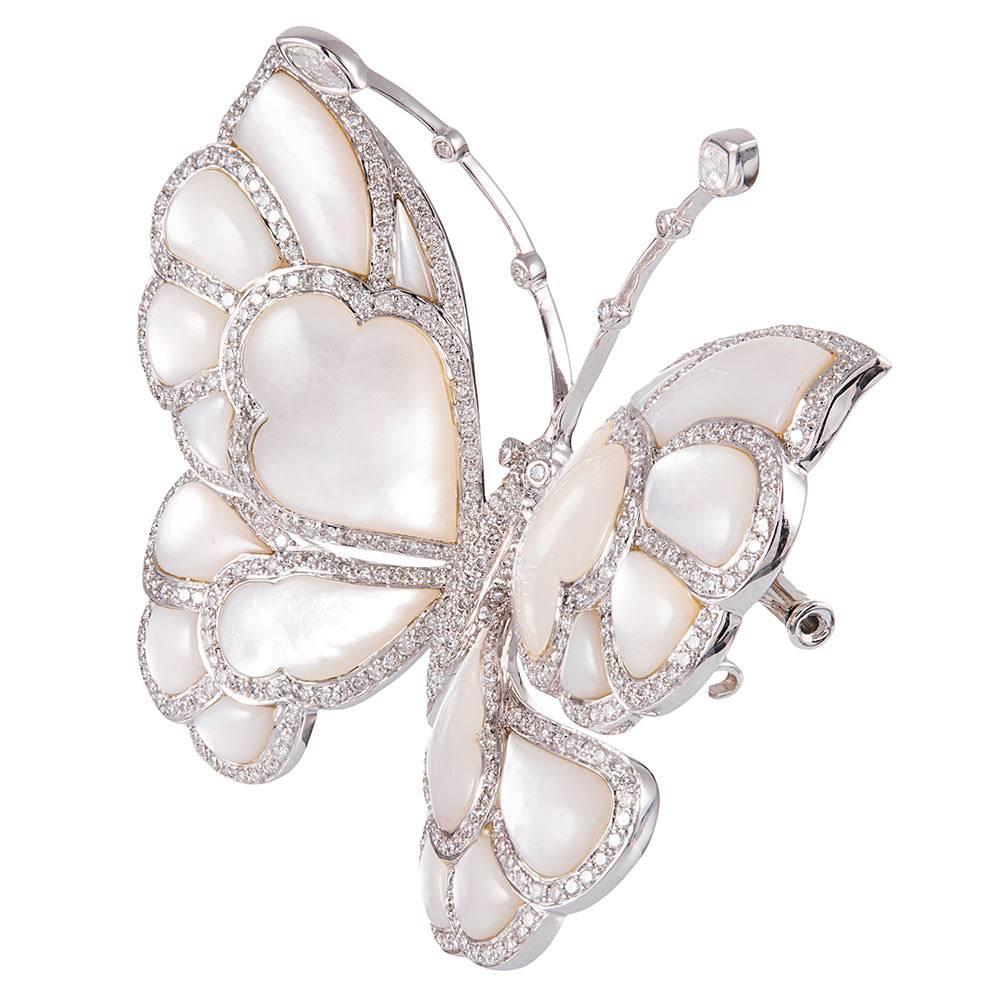 The subtle, mystical allure of mother of pearl catches the light and flashes warm hues of pastel colors in a showy display. Each section of lustrous nacre is framed by brilliant white diamonds, 3.50 carats in total, while the antennae are tipped