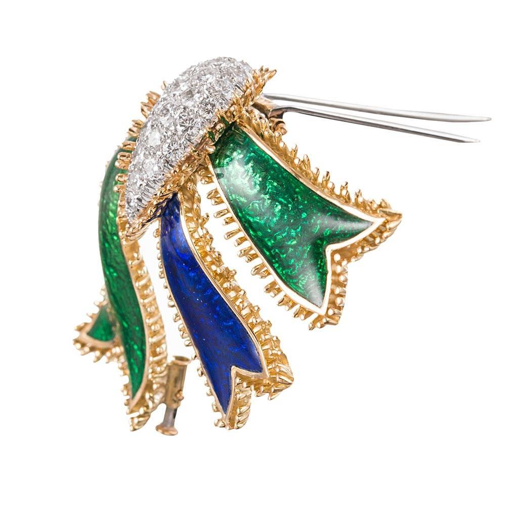 David Webb’s iconic creations are hallmarked by striking combinations of enamel and gemstones. This substantial brooch measures 2.5 by 2 inches and offers bold strokes of Kelly green and admiral blue enamel in dramatic contrast to brilliant diamond