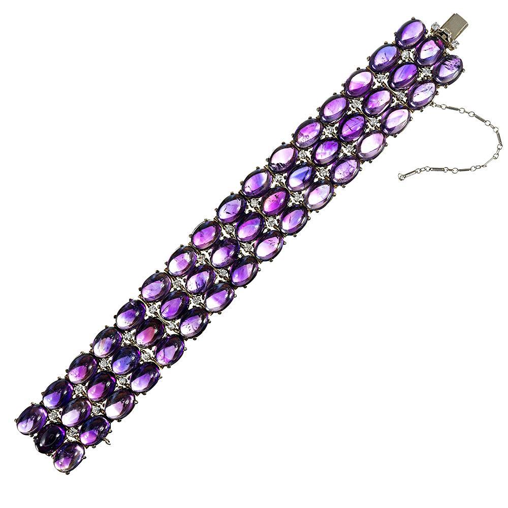 An 18 karat white gold bracelet set with cabochons of amethyst and brightened by the sparkle of brilliant round white diamonds nestled between. The bracelet measures 7 inches long and a hint under 1 inch wide, making it bold enough to be formal or