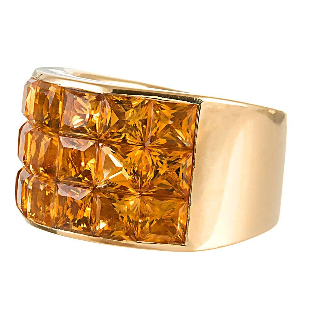 Measuring a generous half inch across the top and gently tapering at the back side, the 18k yellow gold ring is generously appointed with 6.50 carats of square cut citrines. The ring lays comfortably flat against the finger. Size 7.25 can be resized