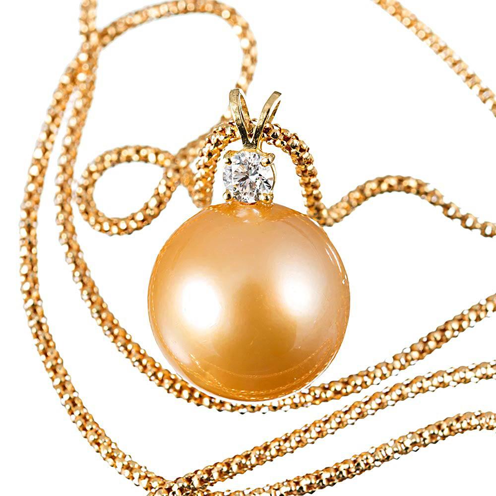 The lustrous pearl is mounted in 18k yellow gold, with a brilliant round diamond sitting atop. The organic charm is augmented by the deep golden color. The diamond weighs .22 carats and exhibits I color with Vs clarity. Suspended from an 18 inch
