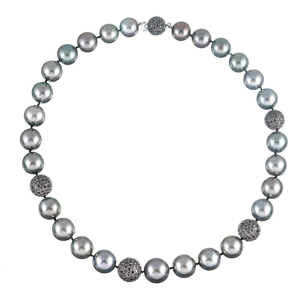 An 18 inch strand of Tahitian South Sea pearls, gently graduated from 12 to 14.9 millimeters and accented with black diamond set rondels. In total, there are 9 carats of diamonds highlighting the lustrous shades of grey and silver exhibited by the