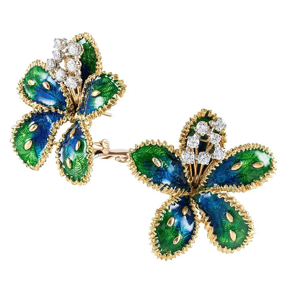 Measuring 1.24 inches in diameter, the three-dimensional petals of the flower are decorated with a subtle guilloche pattern and richly-hued blue-to-green enamel. The cascade of brilliant white diamonds bursting from the center adds a bright pop and