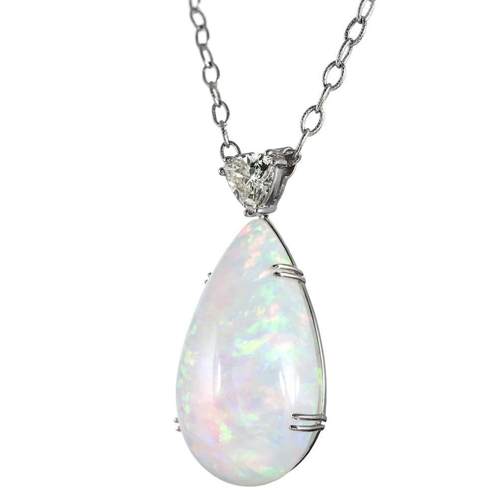 A striking contemporary design, with the pendant fashioned in platinum and suspended from a sixteen inch 14k white gold chain. The opal boasts a dazzling color display including flashes of red, blue, green and orange. It is affixed to a 1.10 carat