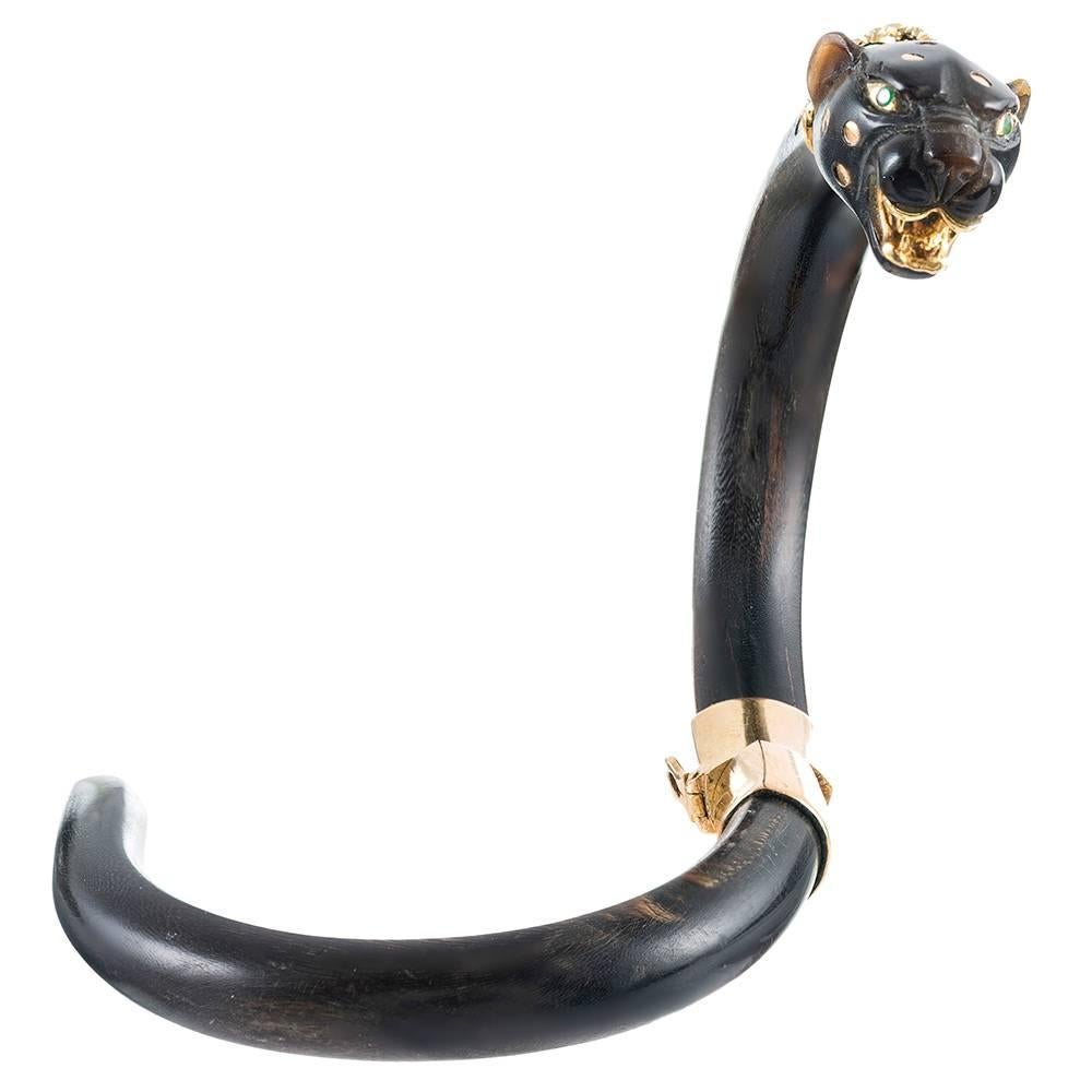 Smooth strokes of ebony are fashioned into the shape of a panther, decorated with a twisted diamond collar, emerald eyes and 18 karat yellow gold accents. The bracelet twists open with a single motion and is secured by a safety latch. The interior