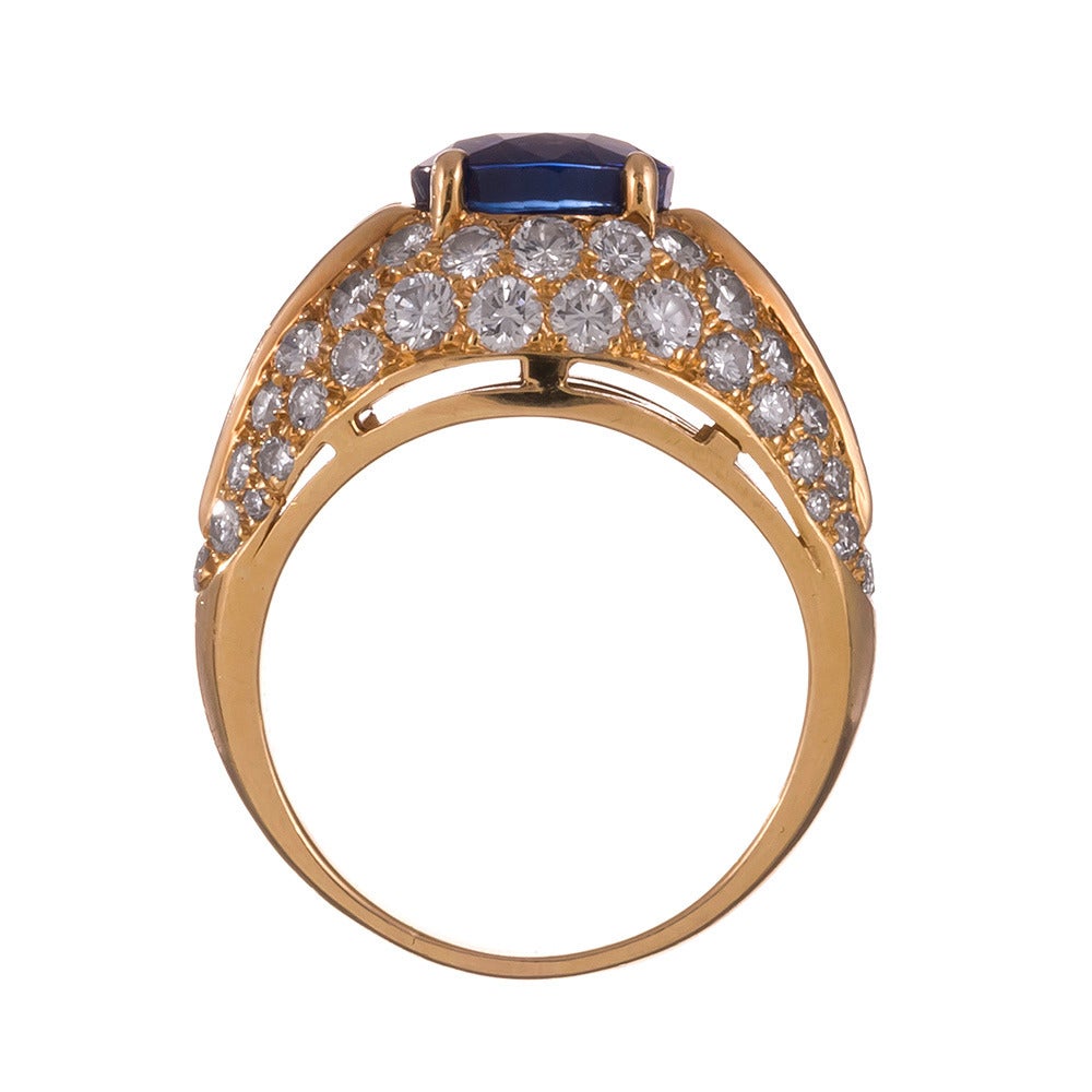 A classically-styled Bulgari ring, using their signature combination of round- and baguette diamonds to illuminate a stunning blue sapphire center stone. The sapphire is a delicious shade of intense blue and every bit the quality one would expect