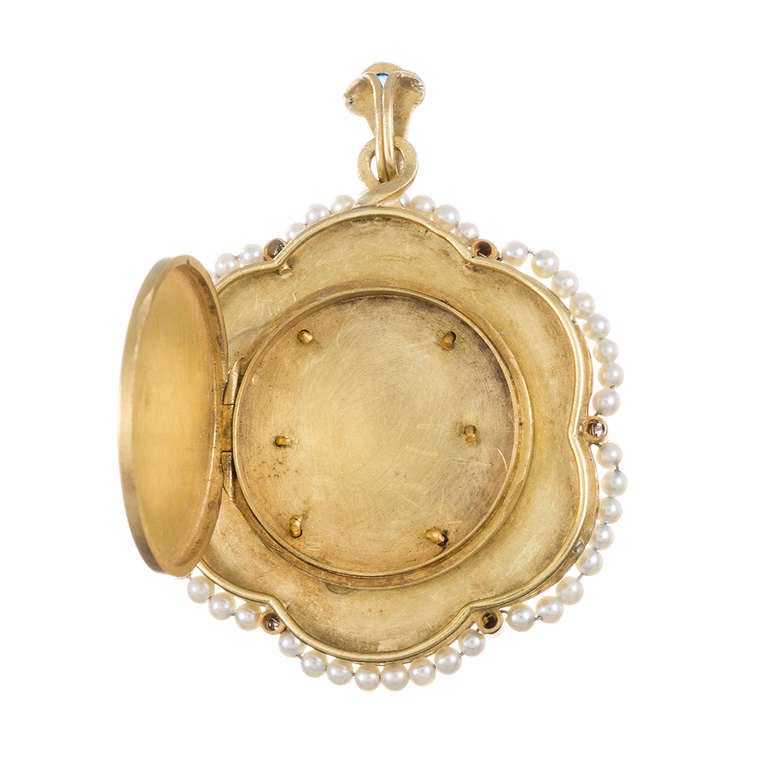 Gorgeous pendant with a locket back: a scalloped border of seed pearls and rose cut diamonds surrounds a carved ivory centerpiece and frames an enamel Madonna at the center. More rose cut diamonds form a halo around her and the pendant is finished