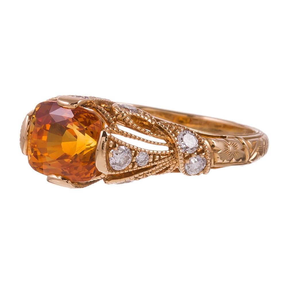 For the non-traditional bride or she who desires the rich, jewel-toned and
versatile hue this spessartite garnet offers. The 2.69 carat center stone
is complimented by an art nouveau-inspired Lucie Campbell mounting in 18k
yellow gold. The