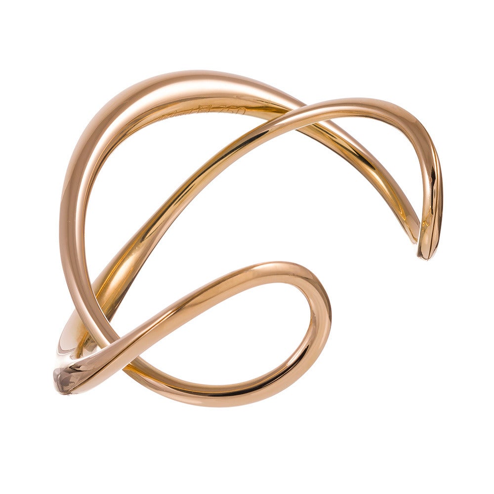 18k yellow gold bracelet, designed as an infinite flow of polished gold.
This piece looks very well over the long sleeve of a fitted sweater and is
equally attractive over bare skin. It is approximately 1 inch wide at its
widest point and the