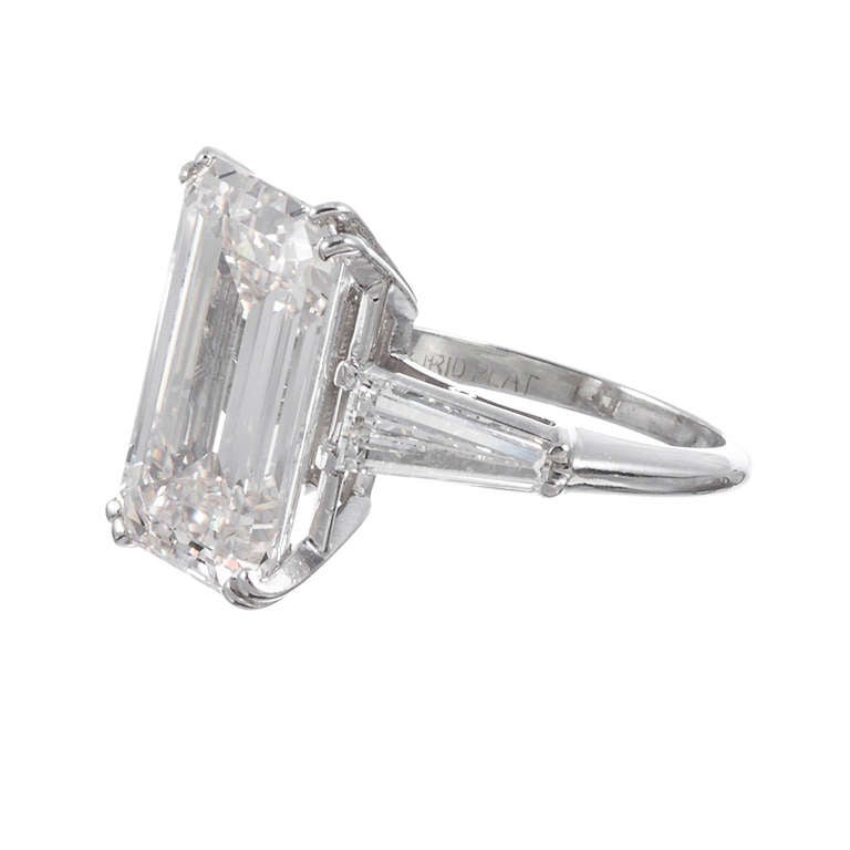 Sophistication and opulence has been achieved with striking simplicity here. An elegant emerald cut diamond of 8.85 carats is displayed with modest .25 carats each baguette accent diamonds and presented in a simple platinum mounting. This ring can