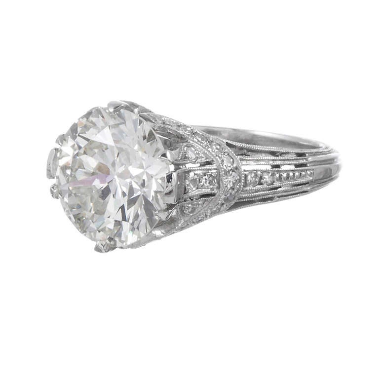 A lovely diamond solitaire with unusual twists and beautiful details. Sweeping strokes of platinum and modest diamond accents form a 