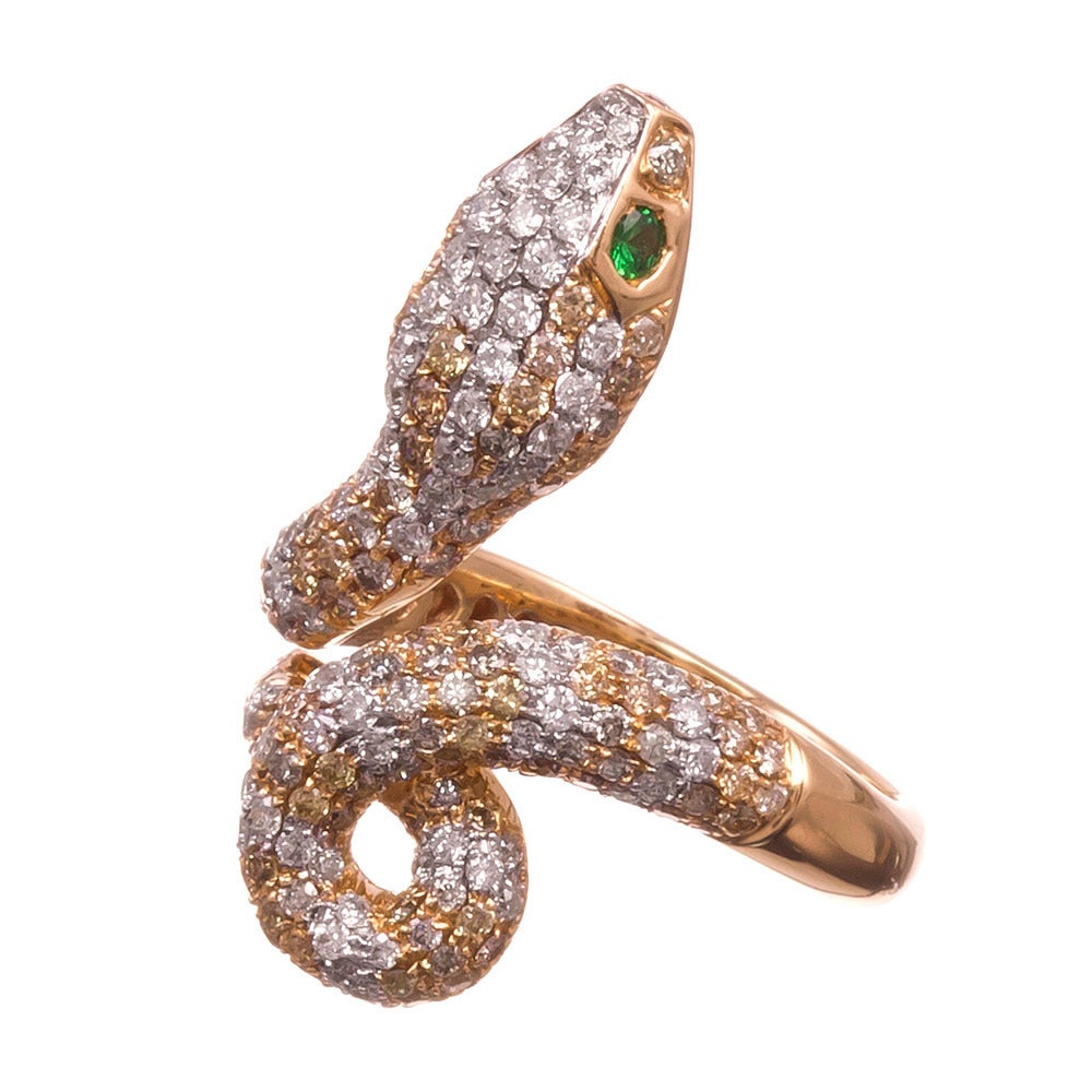 18k yellow gold snake ring, coiled around your finger with lifelike charm, set with 1.43 carats of fancy colored diamonds and .84 carats of brilliant white diamonds. The diamonds are assembled in alternating rows, creating a distinctly reptilian