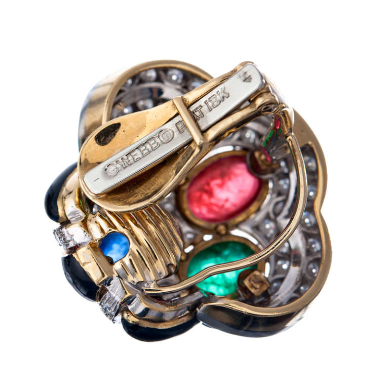 Yet another handsome, bold and striking combination from David Webb. 7 carats of cabochon emeralds, 5carats each of cabochon sapphire- and ruby and 110 diamonds, set in a contemporary geometric pattern with inlaid strips of onyx adding a substantial