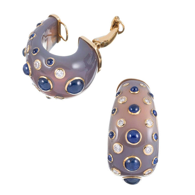 Large hoops of smooth natural chalcedony, peppered with a symmetrical pattern of bezel set cabochon sapphires and full cut brilliant diamonds, signed 