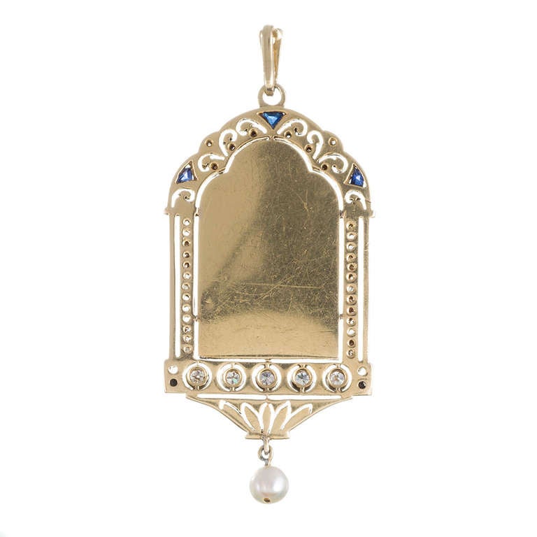 Platinum over gold pendant, an ornate frame of diamonds and custom-cut sapphires and displaying a 