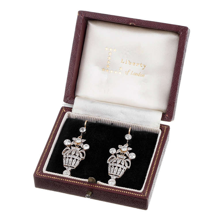 Lovely authentic Edwardian earrings, with a charming basket motif. Rendered in platinum over 18k yellow gold and containing approximately 1.65 carats of old European cut diamonds, the earrings measure 1 5/8 inches in overall length (including the
