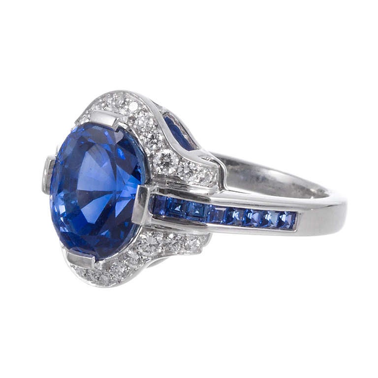 A stunning 6.05 carat intense blue sapphire, set in an art deco inspired platinum mounting and surrounded by a melee of brilliant diamonds and French cut sapphires. This is an absolutely gorgeous stone and offers a size and ring style that can be