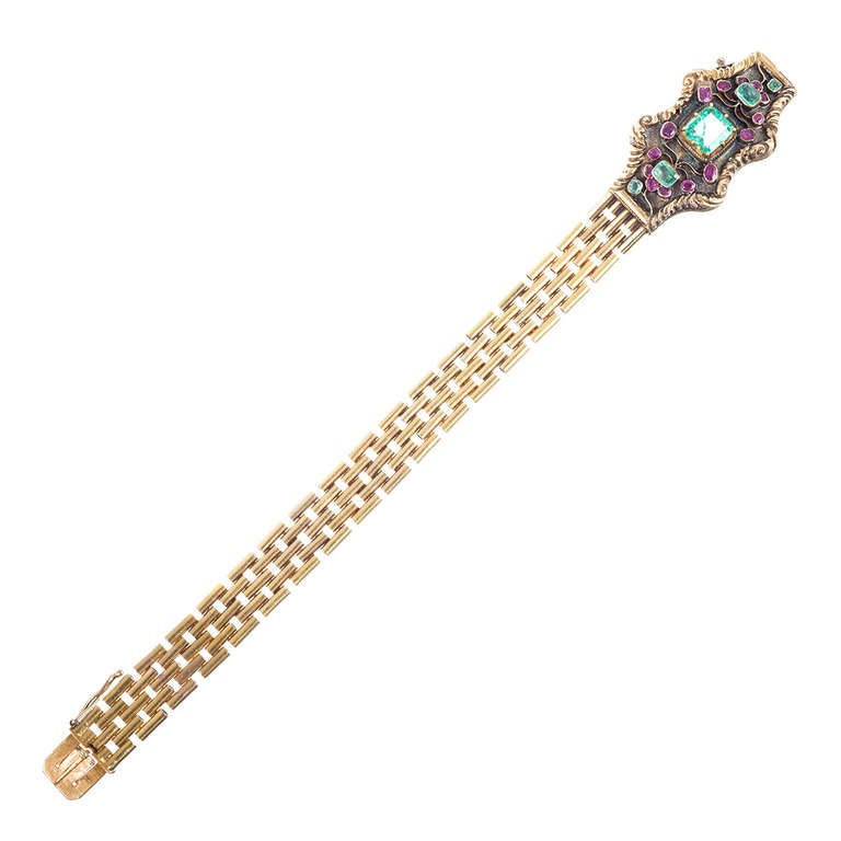18k yellow gold bracelet, consisting of stacked tubes of gold fastened at the front by a plaque set with emeralds and rubies. The hand-craftsmanship is evident, as is the enormous charm of this authentic Georgian treasure. It measures just a hint