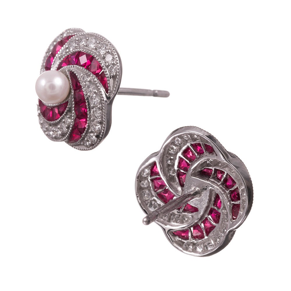“They resemble a turban”… or a pinwheel, yet made of F color, Vvs clarity brilliant diamonds and vibrant red rubies, in a swirling design bordered in mil grain. The earrings measure just a half inch wide, yet the quality of the gemstones speaks for